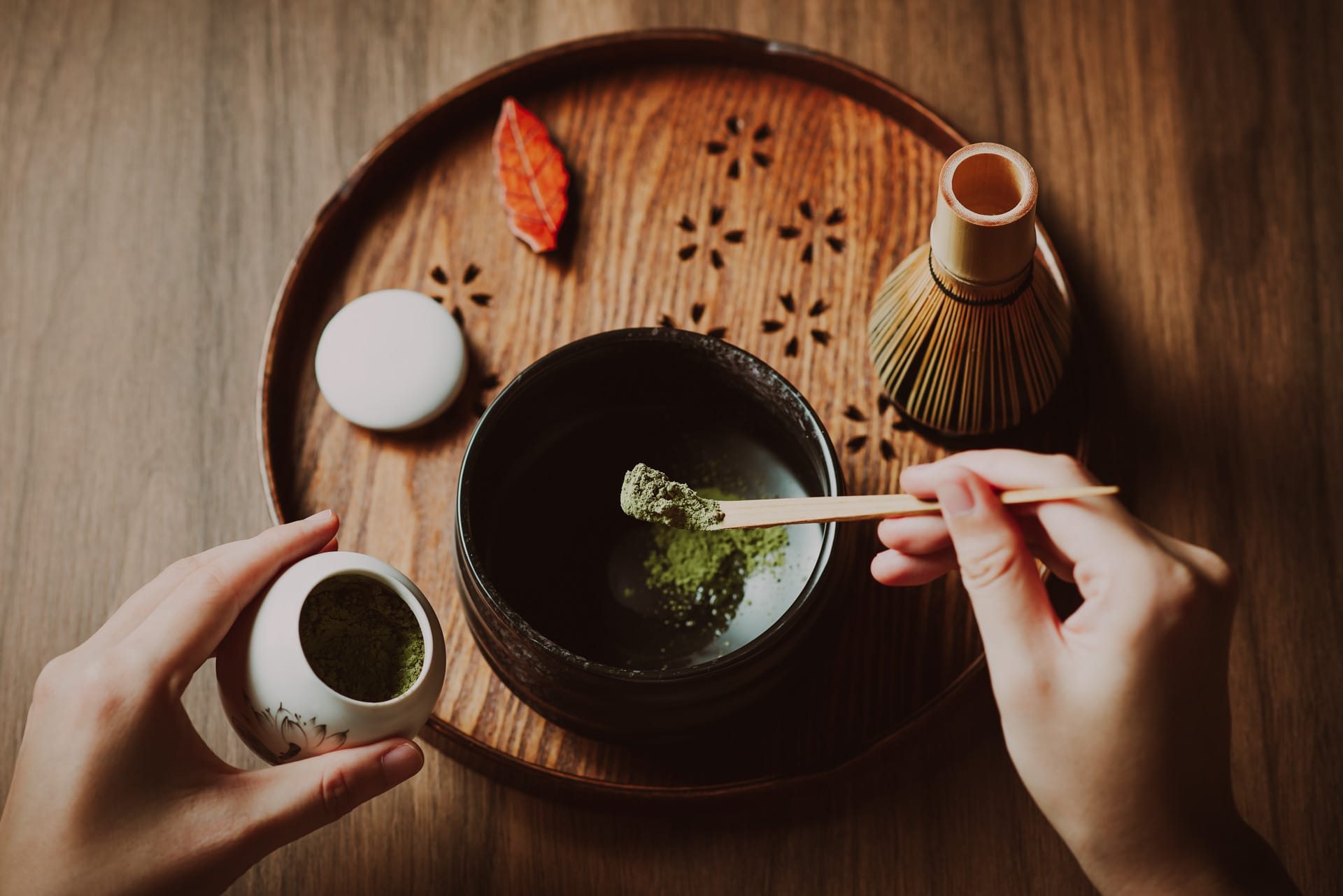 Woman making matcha green tea with traditional accessories for Japanese Asian tea ceremony