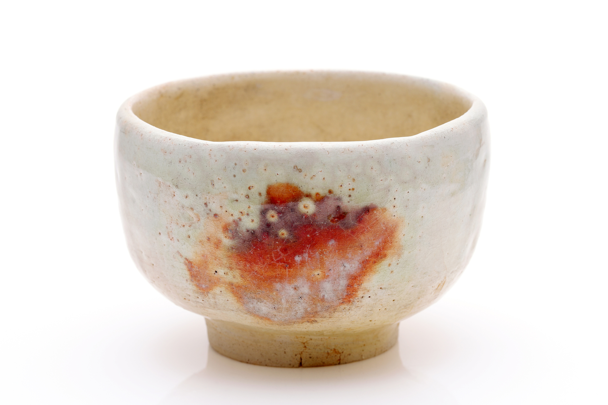A glazed white Chawan tea bowl with a splash of orange decoration