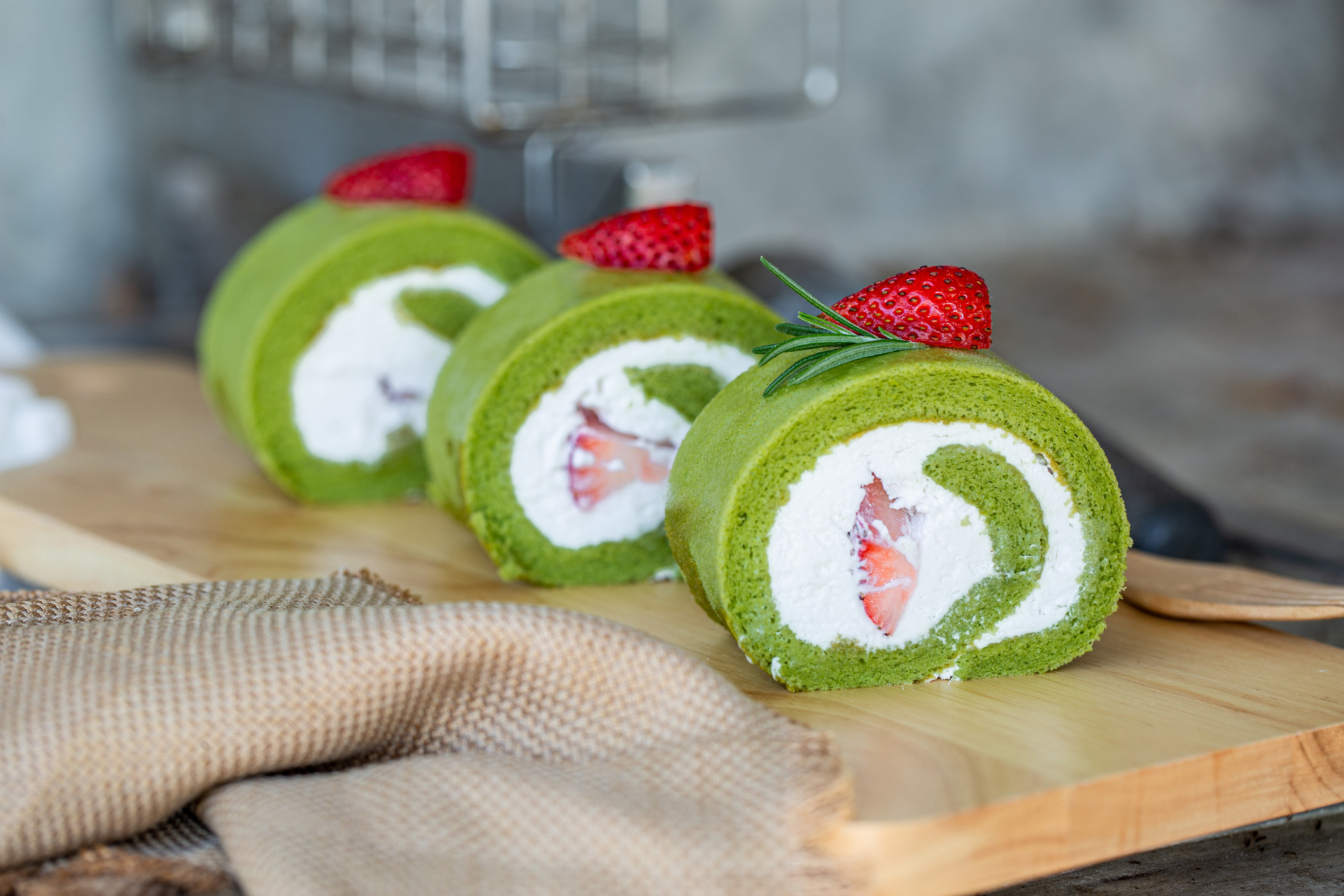 Matcha green tea powder-infused swiss rolls with strawberries.